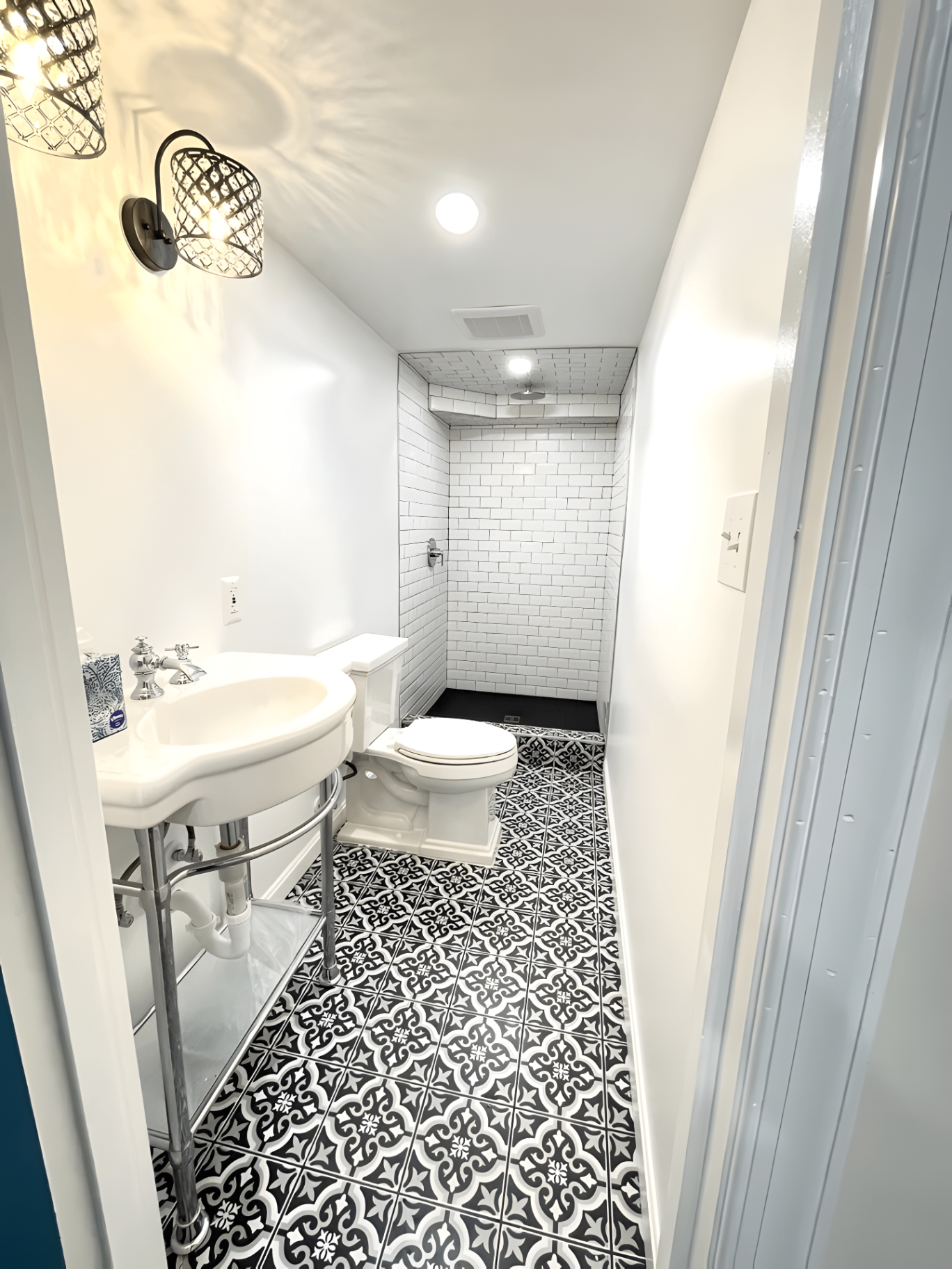 Completed basement bathroom with custom tiled shower and patterned floor