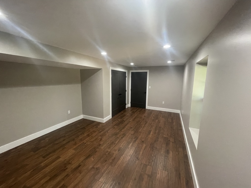 Finished basement from alternate view with modern black doors and square trim