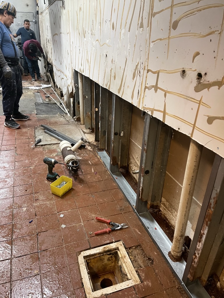 REPAIR IN PROGRESS — Damaged lower wall opened, with deteriorated framing being removed and replaced.