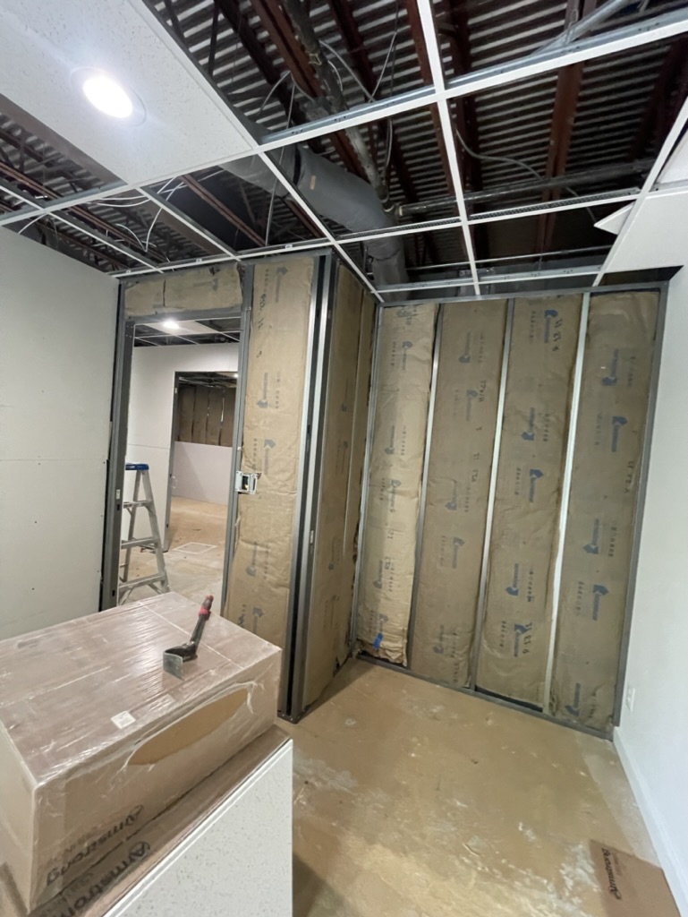 Ceiling grid and wall construction with new ceiling tiles staged