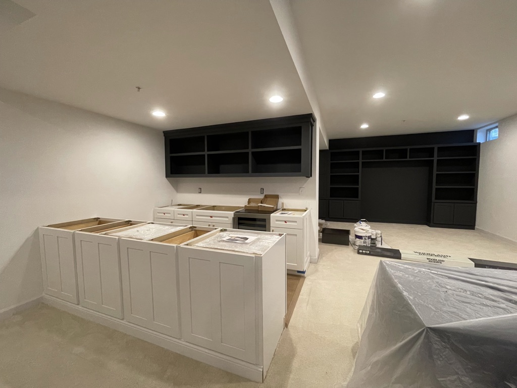 Wet bar cabinet installation with entertainment center in background