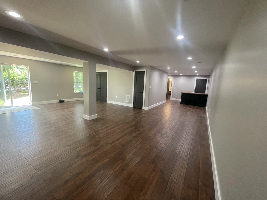 Completed open-concept entertainment area with LVP flooring and recessed lighting