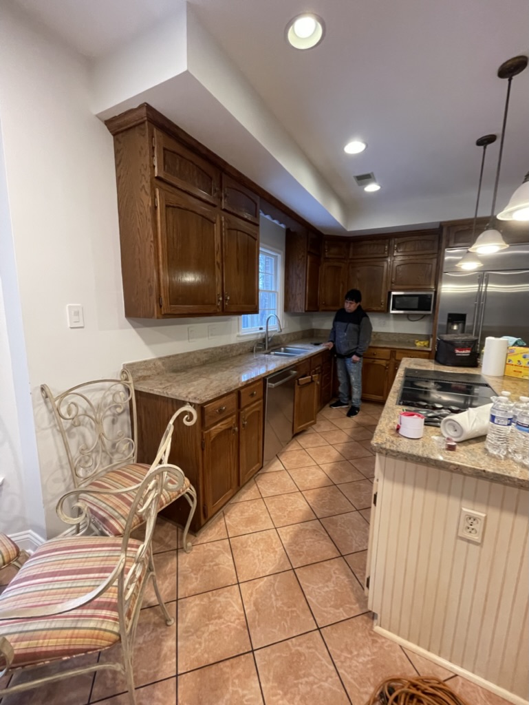 Original sink and cooktop wall with dated finishes and bulkheads above the cabinets