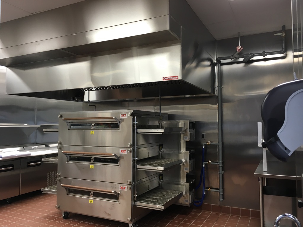 Commercial cooking and ventilation area with stainless-steel wall finishes