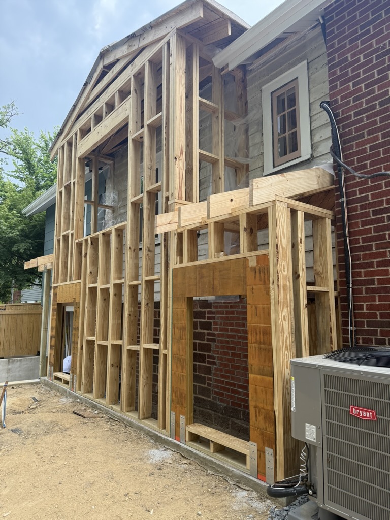 Structural preparation and new wall framing tied into the existing house, with headers and structural connectors