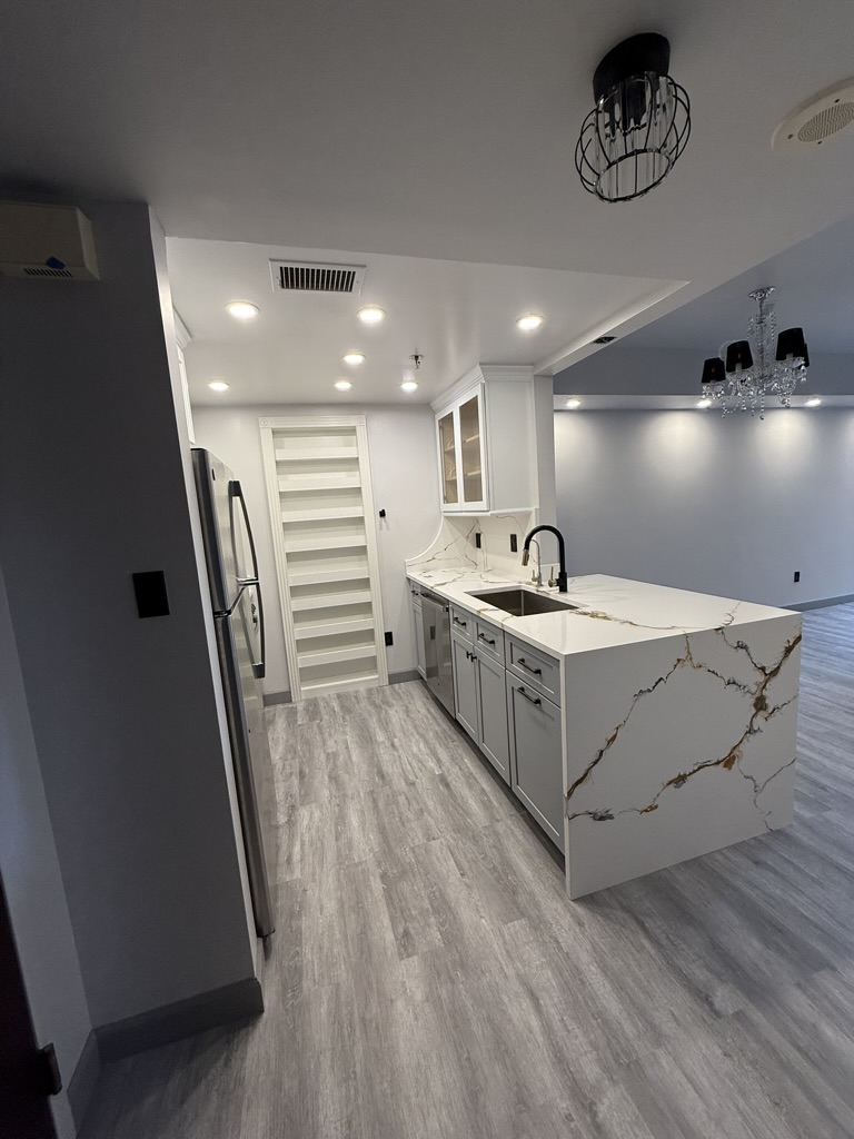 Completed kitchen featuring custom open shelving and seamless connection to the living area