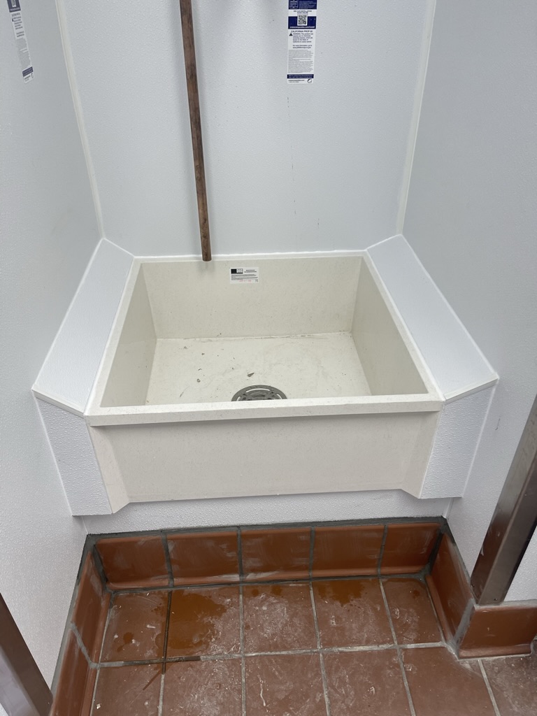 New mop sink installed with finished wall and tile protection
