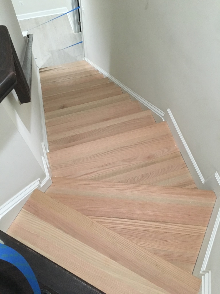 Finished red oak hardwood stair treads with crisp white trim