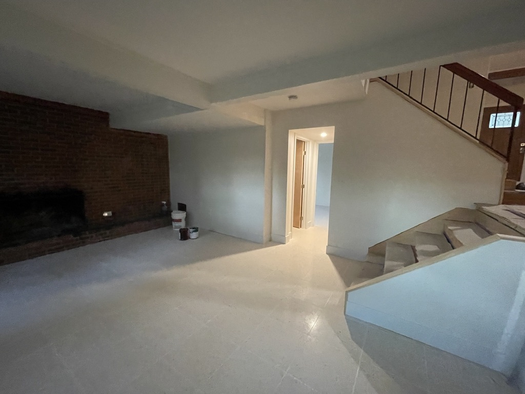 Completed basement living area with finished drywall, fresh paint, ceramic tile flooring, trim, and a clean modern appearance