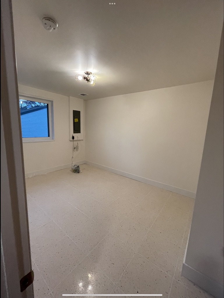 Finished room showcasing completed walls, flooring, lighting, electrical work, and overall professional finish