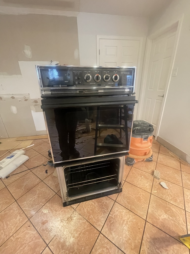 Demolition phase — old appliances and cabinetry removed, walls and floors prepared