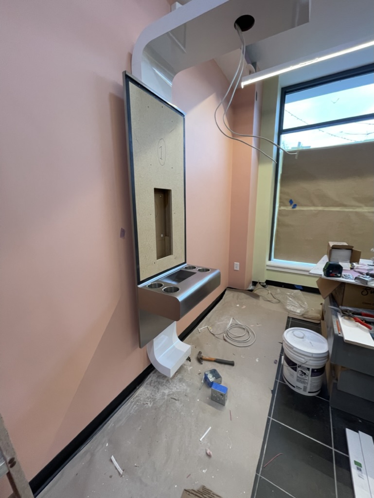 Beauty station and custom mirror unit being installed during construction