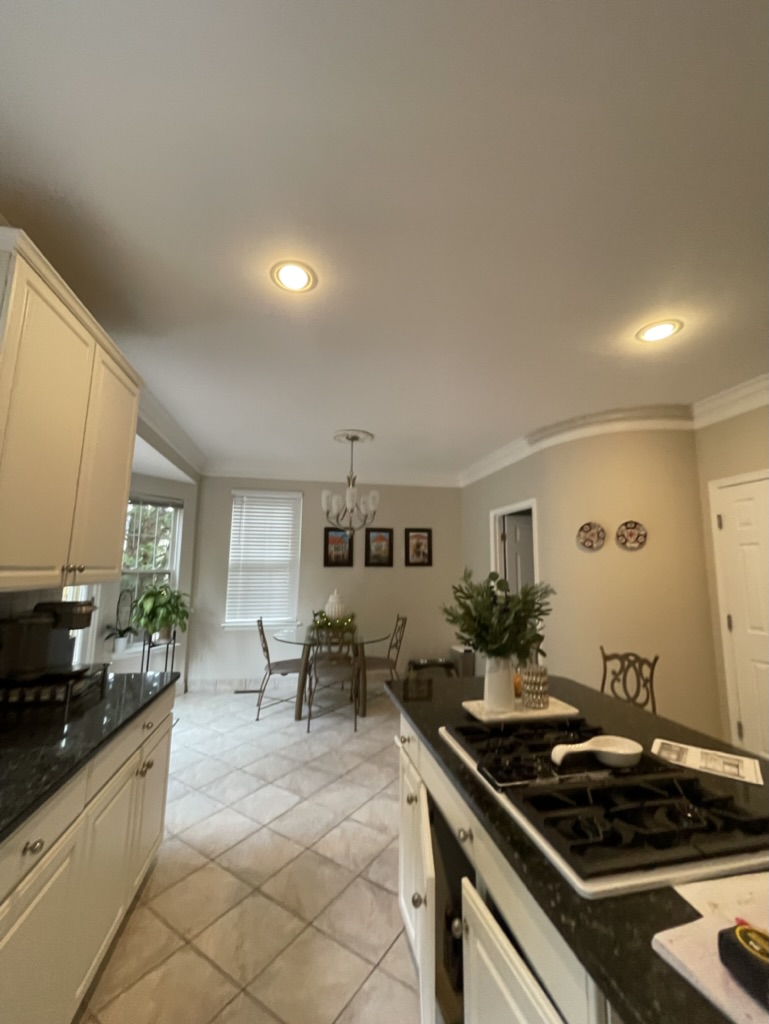 Existing dated kitchen and dining area before renovation — tile floors, dark counters, and aged finishes