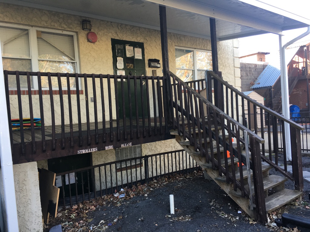 Original aged wood porch and stairs at childcare facility before renovation