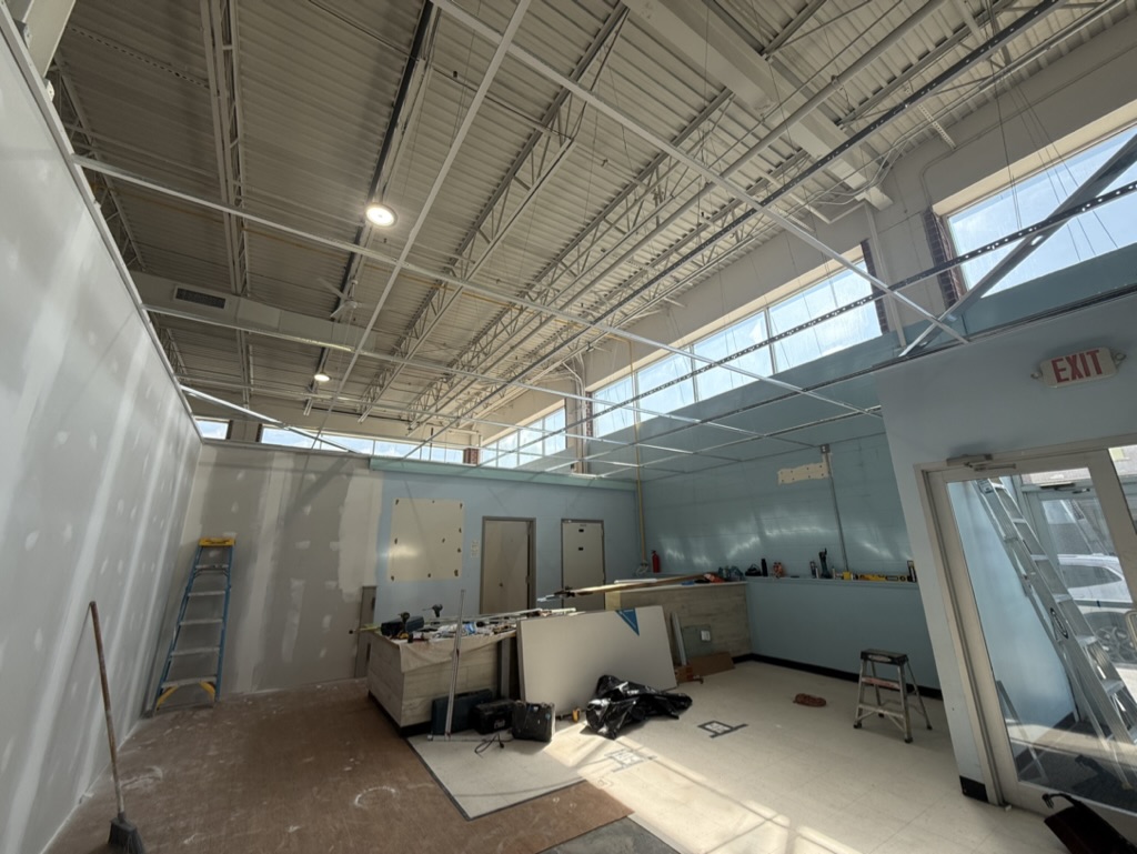 Drywall installation and drop-ceiling grid in progress