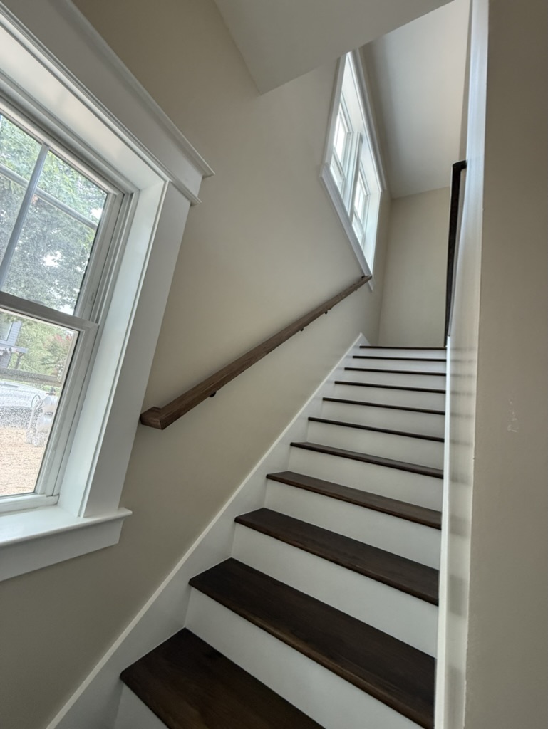 Completed interior staircase connecting the lower basement/garage level to the main living level