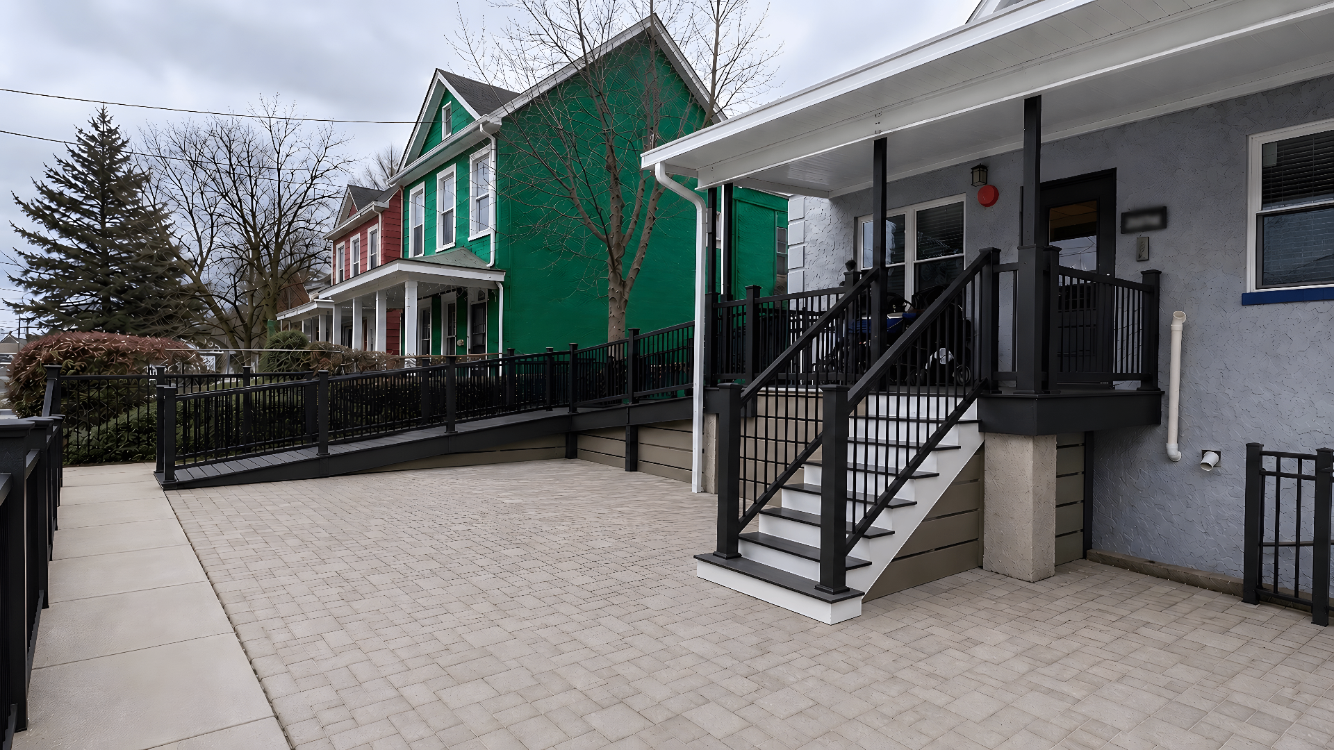 Completed childcare facility renovation with composite decking, white PVC railings, accessible ramp, and upgraded stairs