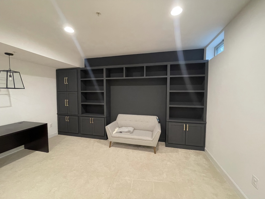 Completed custom entertainment center with built-in shelving and matte black finish