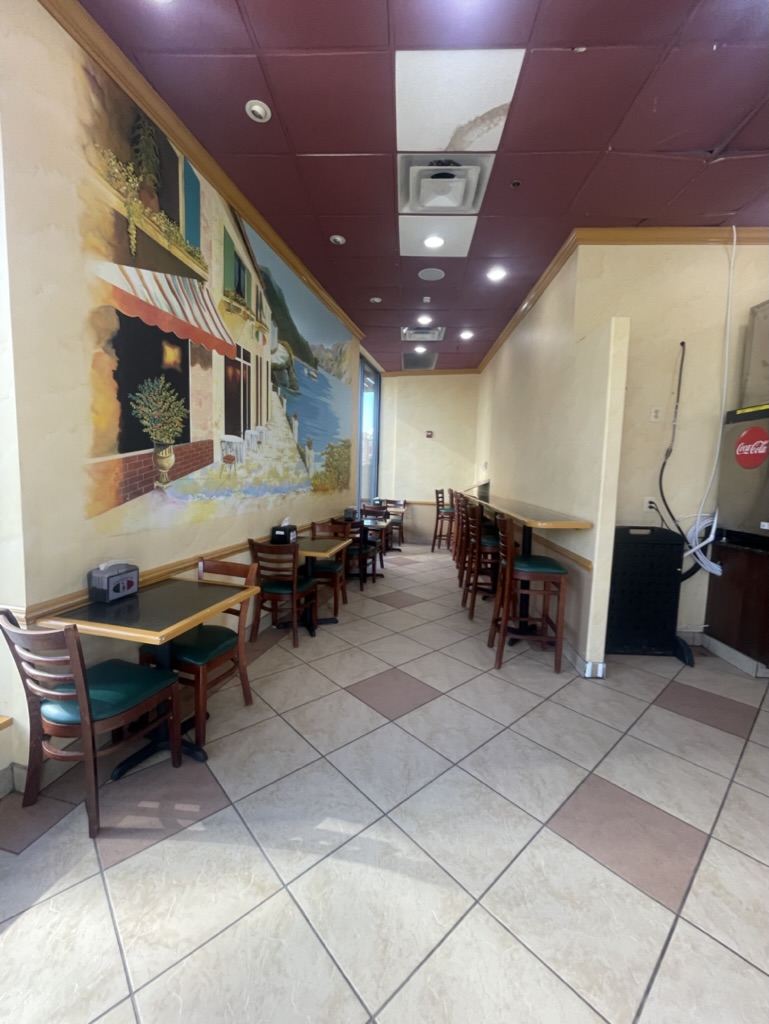 Existing restaurant dining area with original decorative wall mural and dark red ceiling