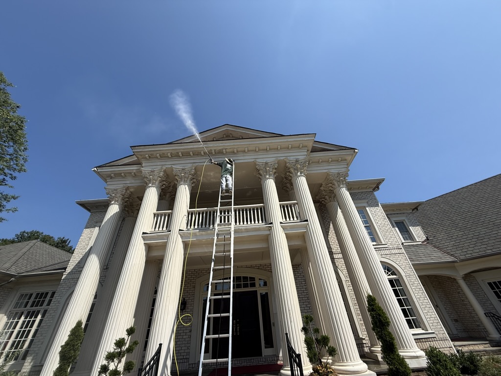 Large residential home exterior being pressure washed by ESM Construction
