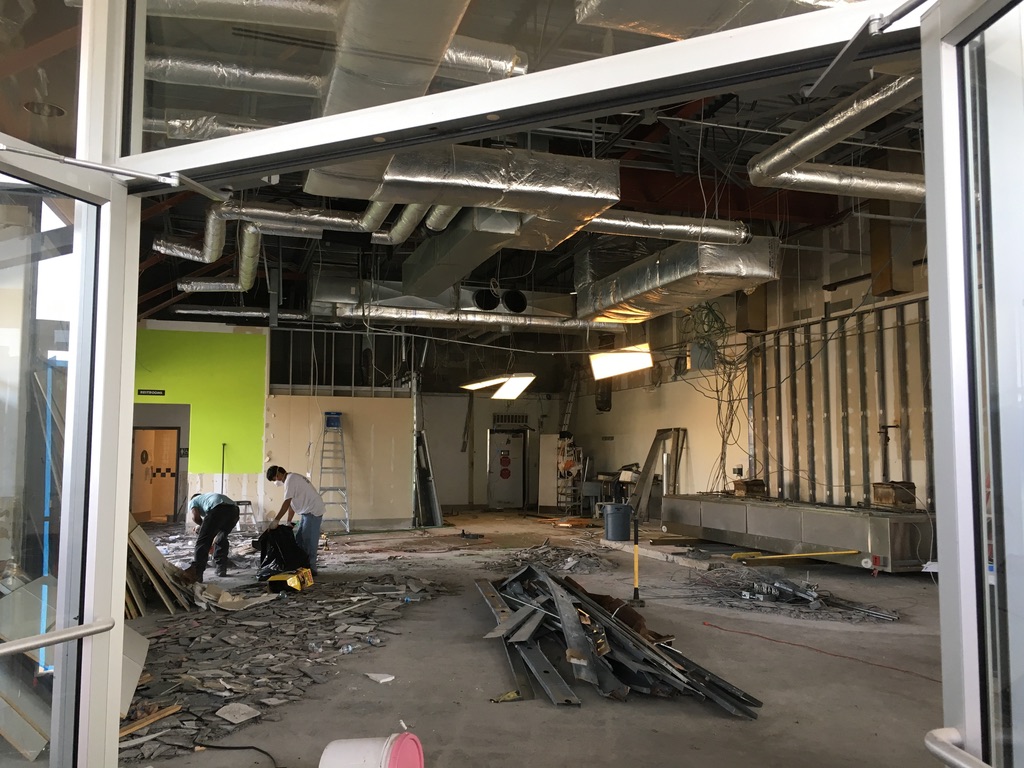 Major interior demolition with exposed ceiling, ductwork, and existing systems