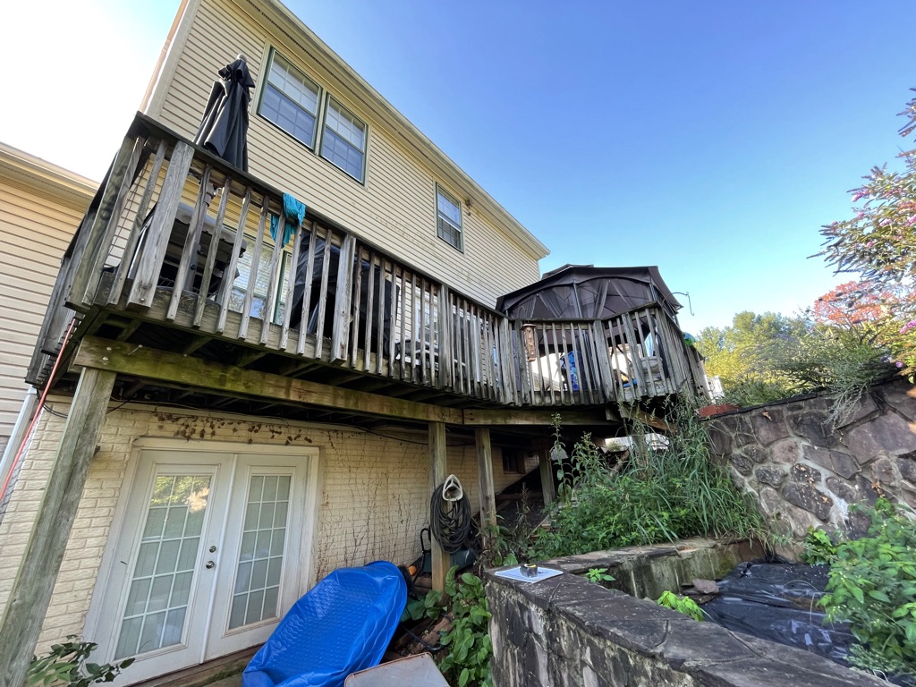 Original weathered pressure-treated wood deck before demolition