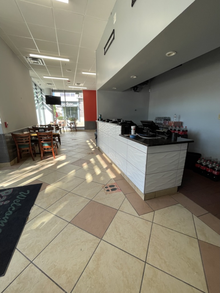 Renovated restaurant interior with white ceiling tiles, new LED lighting, updated wall colors, and refreshed service counter